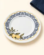 Detalhe do prato branco Family Cook de borda ondulada com arabescos azuis e limões